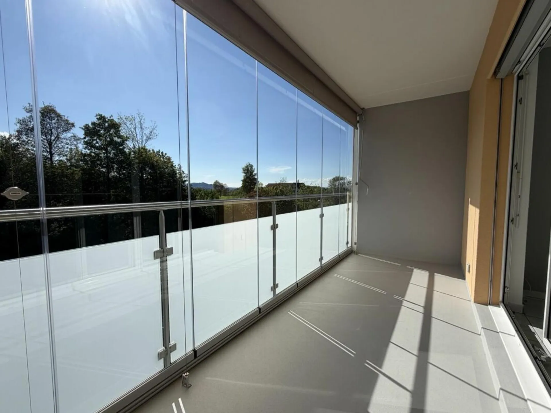 MODERNES WOHNEN MIT VERGLASTEM BALKON UND BLICK INS GRÜNE